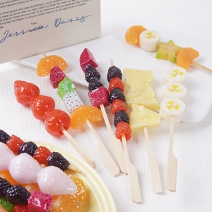 Realistic artificial fruit skewers featuring mixed berries and citrus as decorative props