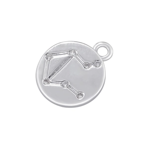 Macro shot of silver Libra zodiac pendant with sparkling zircon inlays on round metal disc