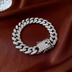 Macro detail of silver iced-out Cuban link chain bracelet with pavé rhinestones