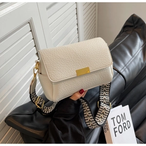 Détail du sac en cuir grainé blanc avec boucle dorée et bandoulière tissée