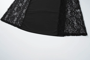 Dettaglio del patchwork in pizzo nero e della trama del tessuto sull'orlo dell'abito