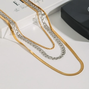 Detailed layered necklace set featuring gold Cuban, silver Figaro, and flat snake chain styles