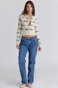 Detail of slim-fit knit cardigan with green leaf patterns and pink bow tie jacquard