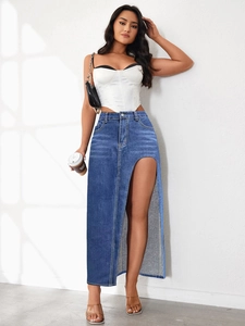Gonna lunga di jeans con spacco alto abbinata a corsetto bianco e borsa a tracolla nera