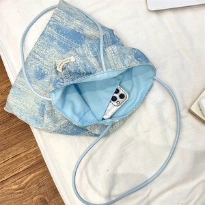 Detailed view of tie-dye lace tote bag interior with blue lining and storage capacity