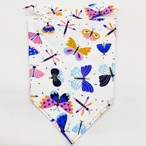 Detail of pet bandana with colorful butterfly and dragonfly prints on white fabric
