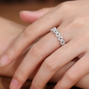 Detailed view of marquise-cut gems on an elegant silver floral eternity ring on finger