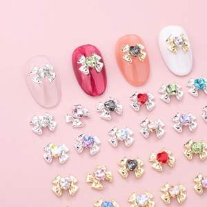 Bowknot nail art charms with heart rhinestones on metal base in various vibrant colors