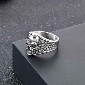 Macro detail of gothic skull ring with textured metal pattern on black gift box edge