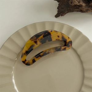 Detailed close-up of tortoise shell pattern hair claw clip with Creation France engraving
