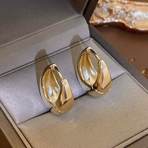 Macro shot of minimalist gold teardrop hoop earrings with S925 hallmark in a gift box
