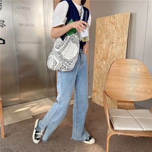 Chic lifestyle photo of a paisley canvas tote bag worn by a model in a modern urban cafe