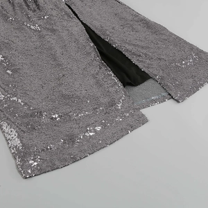 Détail de robe à paillettes argentées montrant la fente latérale et la doublure noire