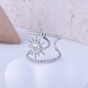 Detail of silver sun motif ring on a white stone with a minimalist double band design