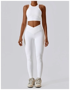 Detail view of white ribbed yoga bra and V-shape high-waisted leggings on a model