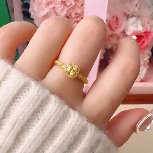 Elegant gold twisted ring with square yellow gemstone and diamond halo on model hand