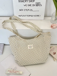 Minimalist off-white canvas tote bag with black polka dots and wide shoulder strap