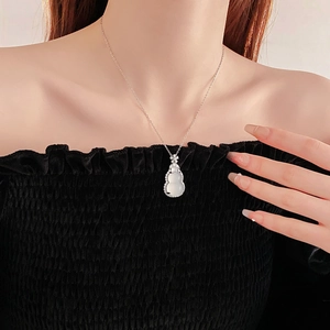 Close-up of zircon gourd pendant necklace with floral accent on elegant female model