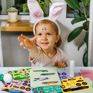 Child playing with colorful racing car DIY stickers featuring trophies and flags