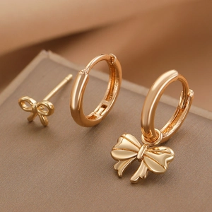 Three-piece gold bow pendant earring set with polished metal hoops and elegant studs
