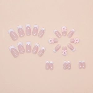 Detail of pink French press-on nails with 3D bows, white pearls and glossy finish
