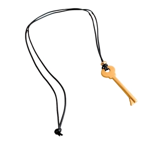 Vintage golden key pendant necklace with black cord and metal accents on white background