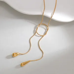 Detailed macro view of 18K gold-plated snake chain with elegant teardrop tassel pendants