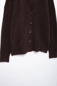 Detailansicht der dunkelbraunen flauschigen Strickjacke mit passenden Knöpfen