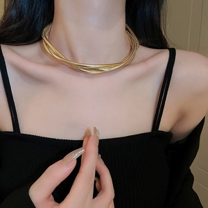 Close-up of golden multi-layered snake chain necklace worn on a model's neck