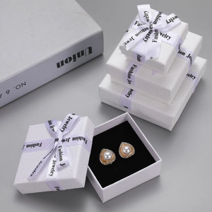 Macro view of heart pearl earrings with gold base in a white lychee pattern jewelry gift box