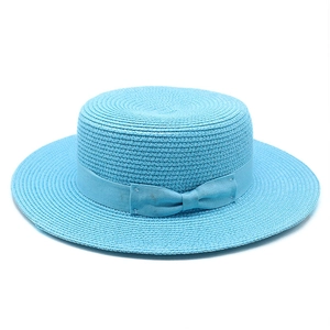 Detail of light blue boater hat featuring fine weave texture and elegant grosgrain bow