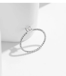 Detailed macro view of silver beaded ring band with a square moissanite stone setting