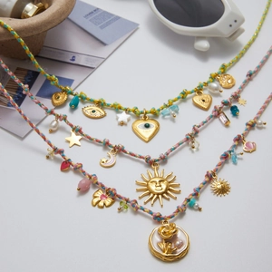 Close-up of bohemian layered necklace set with evil eye and star charms on white background