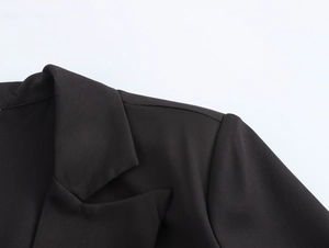 Detail shot of the collar and shoulder stitching on a long black double-breasted blazer