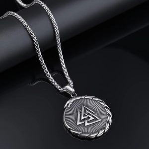 Macro shot of silver Viking Valknut pendant featuring wheat chain and woven texture