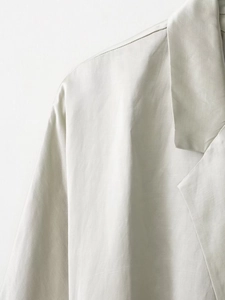 Dettaglio del blazer grigio chiaro che mostra la trama del tessuto e le cuciture del revers