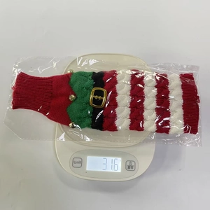 Close-up of a striped Christmas knitted bottle cover with belt buckle on a scale