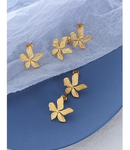 Detailed macro view of 18k gold plated stainless steel earrings with textured petals
