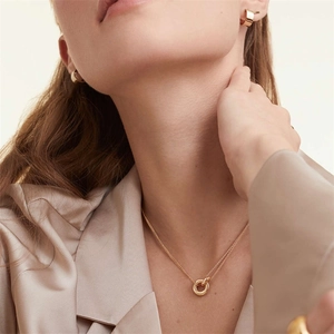 Elegant two-tone stainless steel layered necklace and chunky gold hoops on model