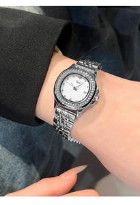 Close-up of luxury silver-tone watch with crystal-encrusted bezel on a woman's wrist