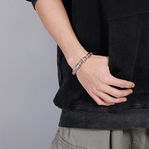 Gros plan d'un bracelet gourmette ovale en acier argenté avec fermoir barre pour homme