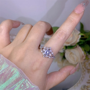 Close-up of sparkling flower ring with central cubic zirconia and halo diamond setting