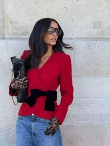 Chic red V-neck blazer with oversized black velvet bow belt for festive street style