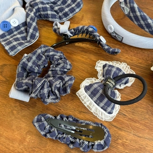 Detailed set of blue and white checkered hair accessories with lace edges on wood