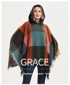 Detail view of multicolored plaid hooded poncho with decorative fringe hem for winter