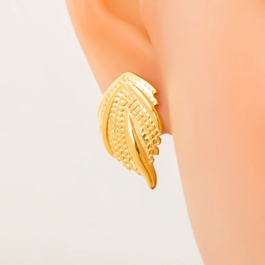 Detailed view of textured golden leaf earrings on model for a minimalist style