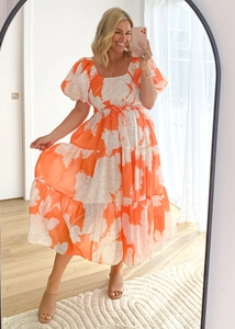 Detail of elegant off-shoulder floral dress featuring puff sleeves and tiered midi skirt