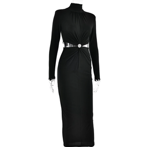 Détail de la découpe à la taille et boucle argentée sur une robe noire à manches longues