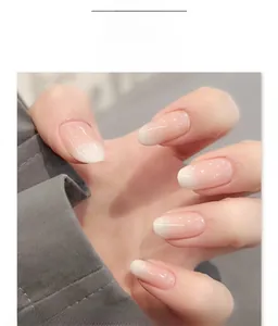 Close-up of pink and white ombre gradient press-on nails in oval shape with polished finish