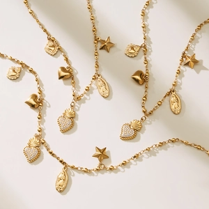 Gold beaded necklace featuring celestial star and sacred heart pendants with crystal accents